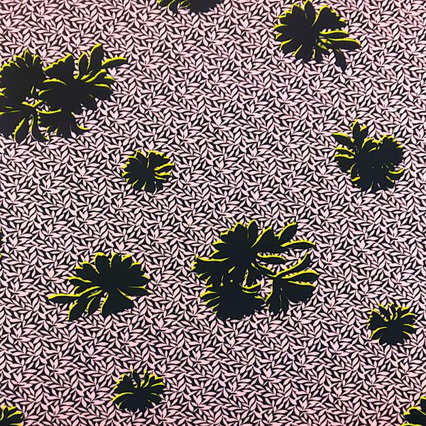 Coupon de tissu crêpe en polyester imprimés de fleurs stylisées noires bordées de jaune sur un fond noir et petites feuilles roses 3m x 1,40m